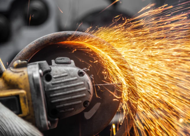 Close-up of an angle grinder cutting metal with bright sparks flying